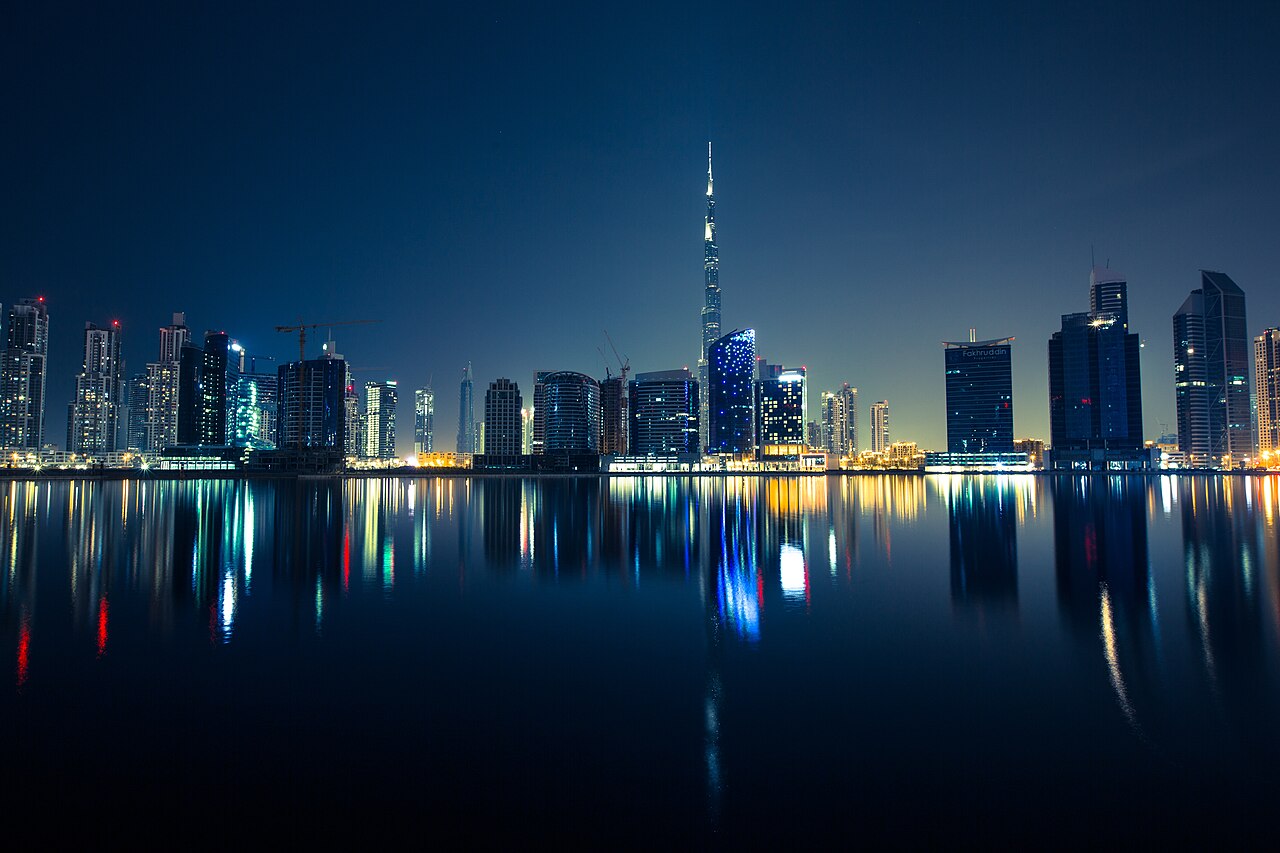 La skyline de Dubaï illuminée et ses reflets dans l’eau.