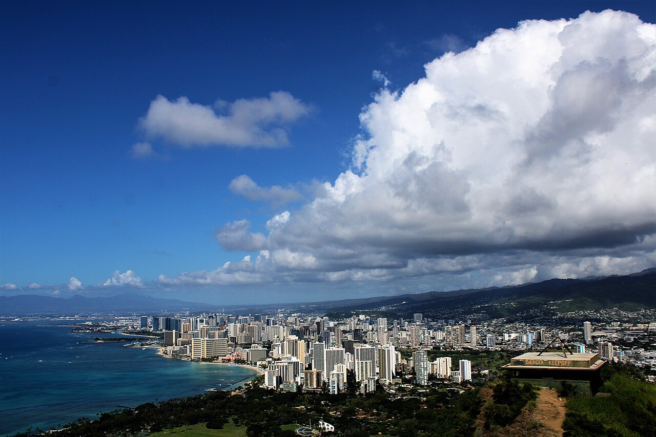 Vue aérienne de la côte de Waikiki, des tours d’Honolulu et des montagnes d’Oahu sous un ciel nuageux